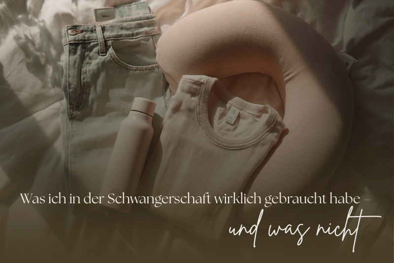 Flatlay mit Schwangerschafts-Essentials: Umstandshose, Stillkissen, Wasserflasche und T-Shirt in sanften Pastelltönen auf einem Bett.